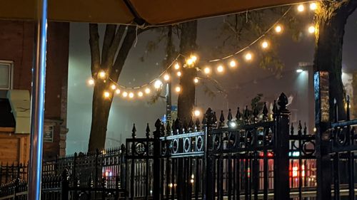 Illuminated street lights by buildings in city at night