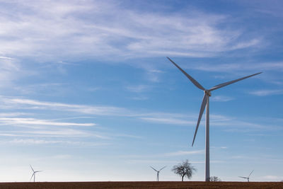 Low angle view of windmill on landscape against sky