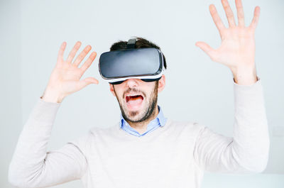 Midsection of man wearing virtual reality glasses against white background