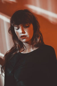 Close-up of woman against wall at home