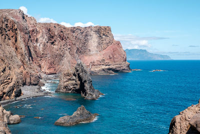 Rock formation in sea against sky