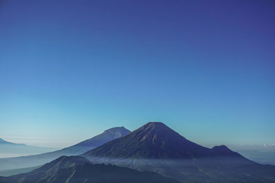 Scenic view of snowcapped mountain against blue sky