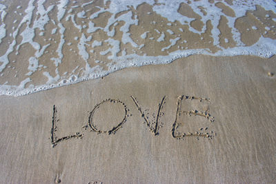 High angle view of text on sand at beach