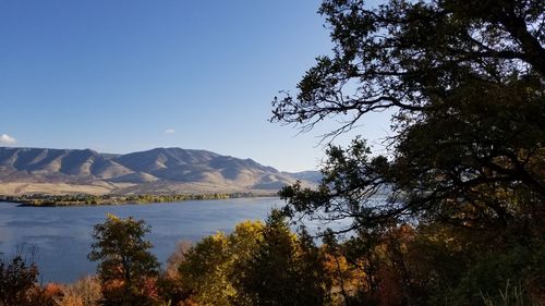 Scenic view of lake and mountains against clear sky