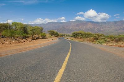 Herd of goats on an empty highway against mountains in iten - kabarnet road in baringo county