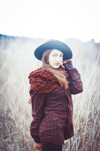 Young woman wearing hat standing on field