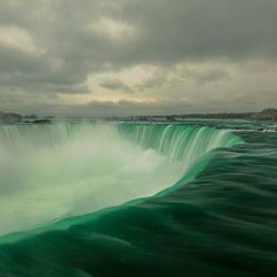 Scenic view of waterfall against sky