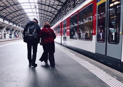 Full length of people walking on railroad station platform