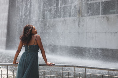 Portrait of beautiful african american woman smiling and looking away at park during sunset. 