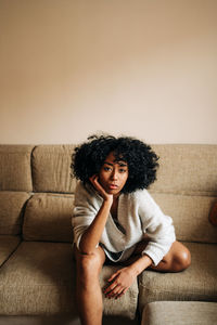 Portrait of young woman sitting on sofa