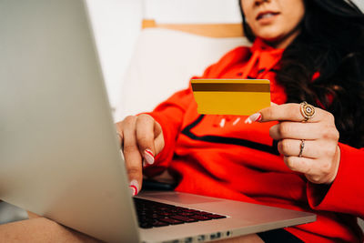 Midsection of woman using mobile phone while sitting on table