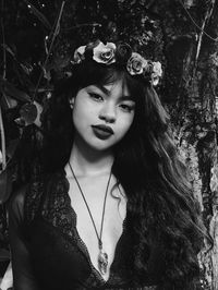 Portrait of smiling young woman against plants