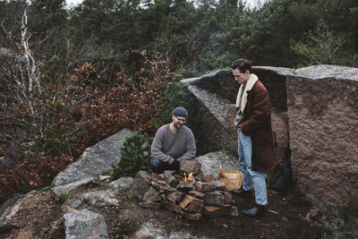 People sitting on rock in forest