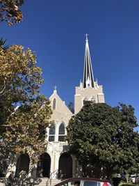 Low angle view of trees and building against sky