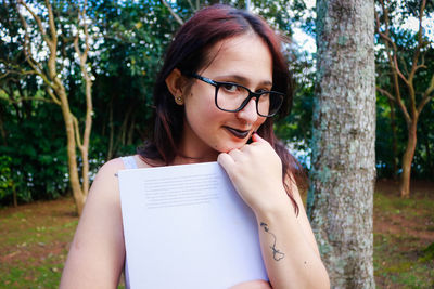 Close-up portrait of young woman holding book