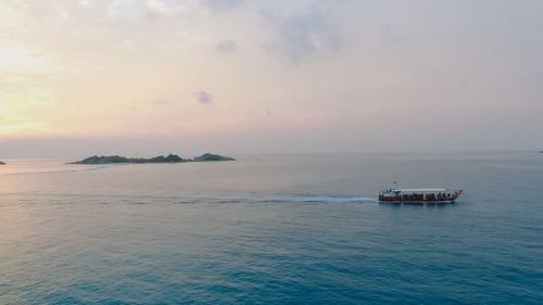 Scenic view of boat in sea against sky during sunset