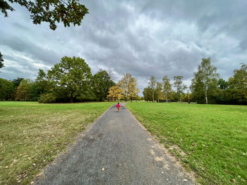 Road amidst field against sky