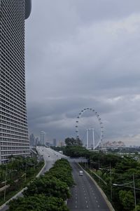 View of city street against cloudy sky