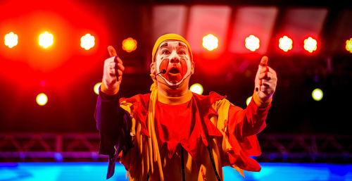 Clown gesturing thumbs up while performing on stage