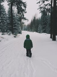 Woman walking on snow covered landscape