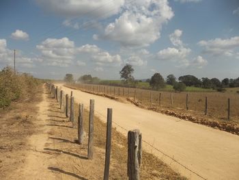 Empty road on field against sky