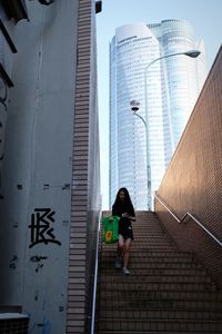 Low angle view of woman walking on staircase of building