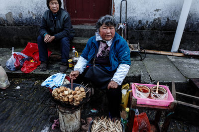 Man and woman sitting at market stall