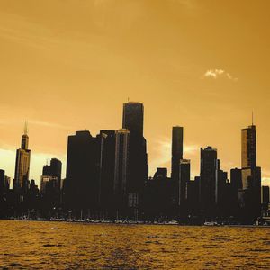 Silhouette cityscape against sky during sunset