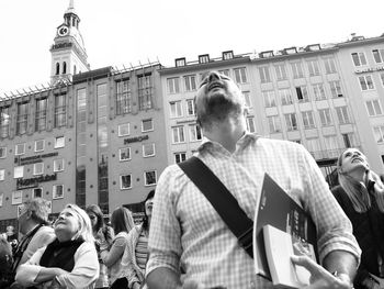 People on street against buildings in city