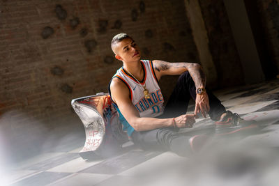 Full length of young woman sitting on floor