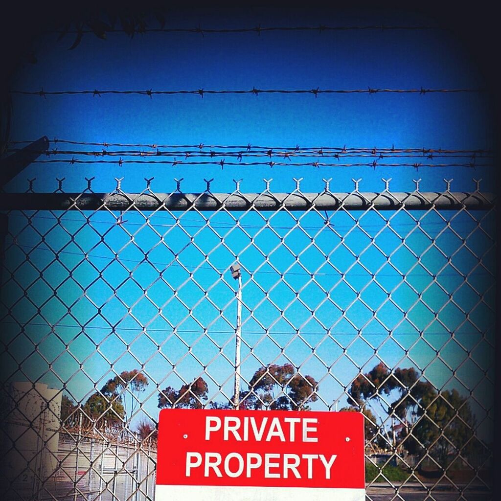 text, western script, communication, safety, metal, sky, fence, chainlink fence, information sign, low angle view, sign, security, protection, information, capital letter, warning sign, guidance, outdoors, no people, forbidden