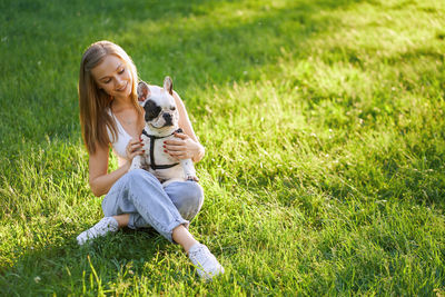 Full length of woman with dog on field