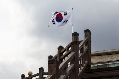 Low angle view of south korean flag on wooden railing at observation point