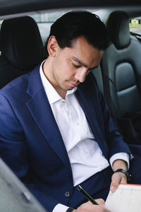 Businessman preparing strategy sitting in electric car