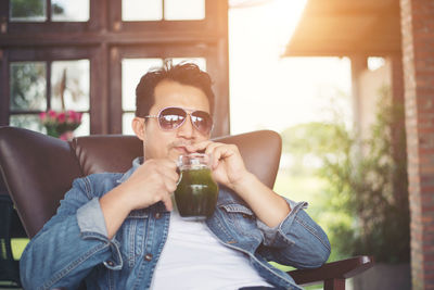 Young man drinking juice at cafe