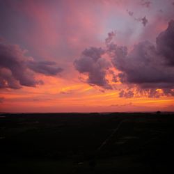 Scenic view of silhouette landscape against orange sky