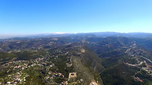 Scenic view of mountains against blue sky