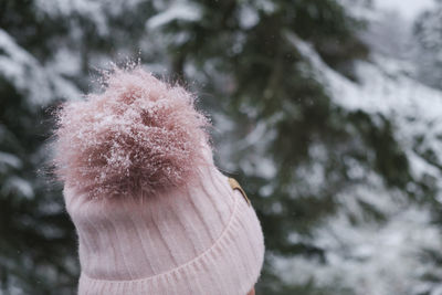 Close-up of woman with bobble hat in forest during winter