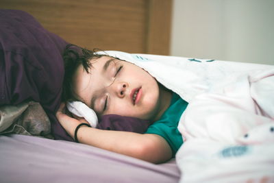 Portrait of boy sleeping on bed