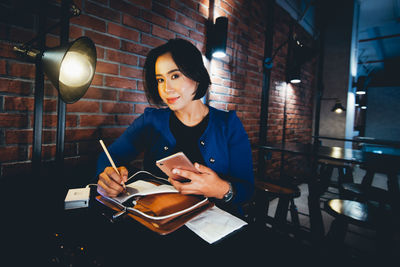 Portrait of young woman reading book