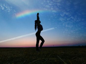 Low angle view of silhouette woman on field against sky