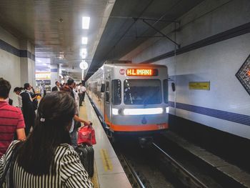 Rear view of people on railroad station platform