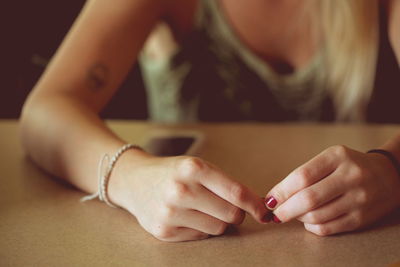 Midsection of woman hands on table