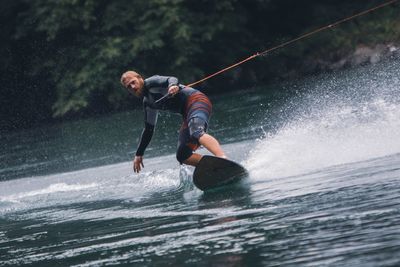 Full length of man splashing water in river