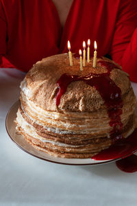 Midsection of woman with cake on table