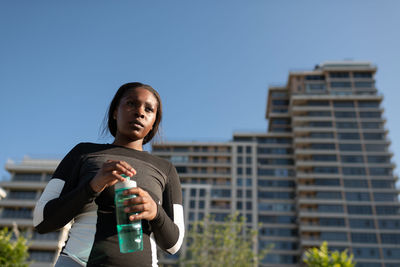 Black runner opening bottle of water