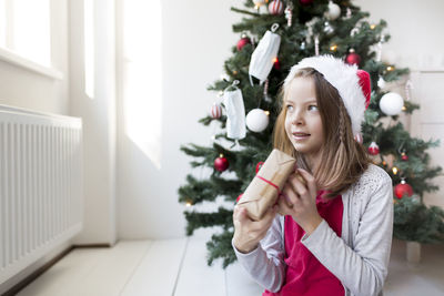 Girl against christmas tree at home