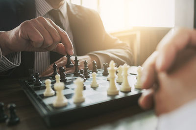 Midsection of man playing with chess