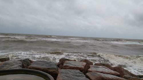 Low section of man on beach against sky