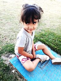 Thoughtful girl sitting on grassy field